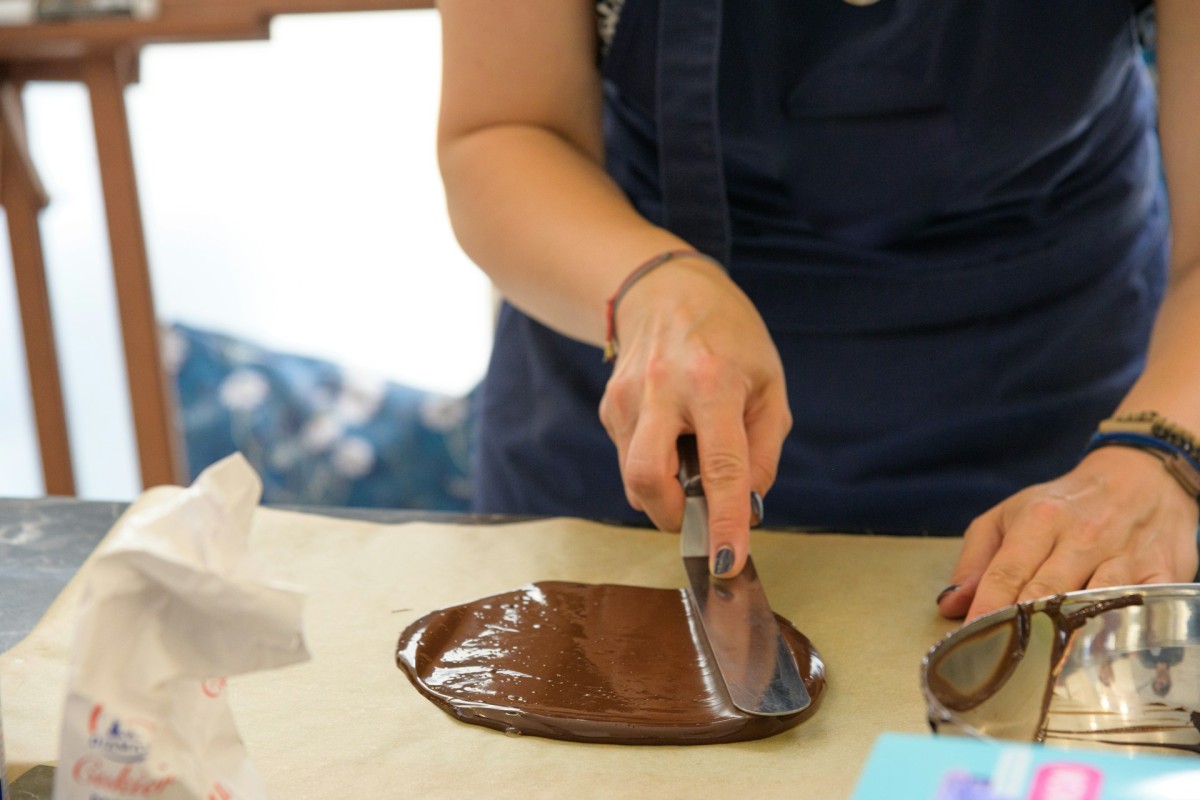 A woman decorating a piece of chocolate, Photo by Joanna Stolowicz, Free to use under the Unsplash Licence